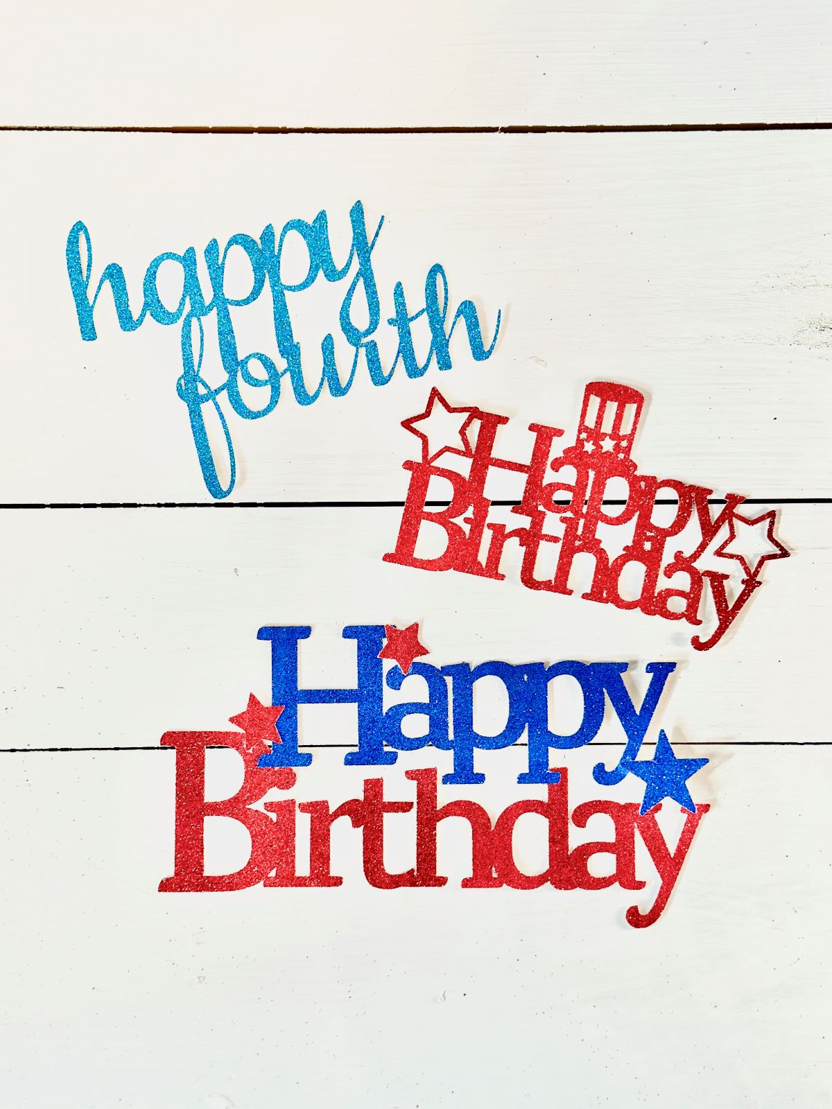A "happy fourth" and two "happy birthday" fourth of july cake toppers.